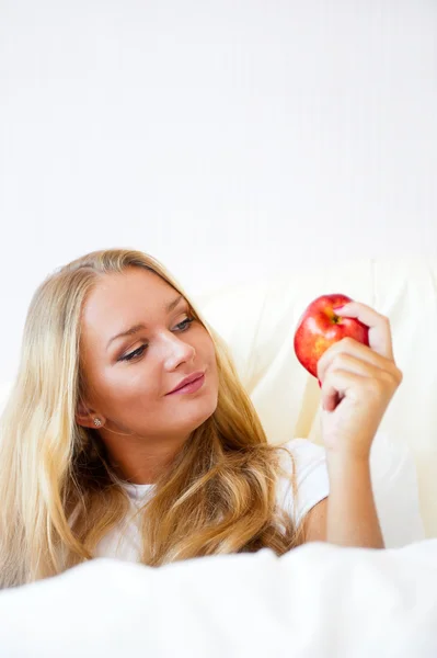 Joven hermosa mujer con manzana en la cama por la mañana —  Fotos de Stock