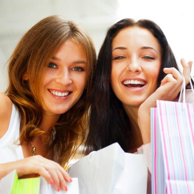 Two happy women at a shopping center with bags. Seasonal prepart clipart