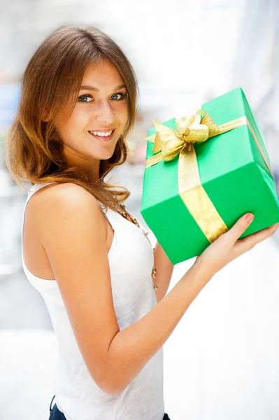 Vacker brunett kvinna med en gåva fält står inne i Shop — Stockfoto