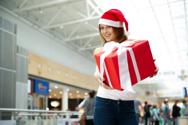 Захватывающая привлекательная женщина с большой подарочной коробкой, стоящей перед магазинами — стоковое фото