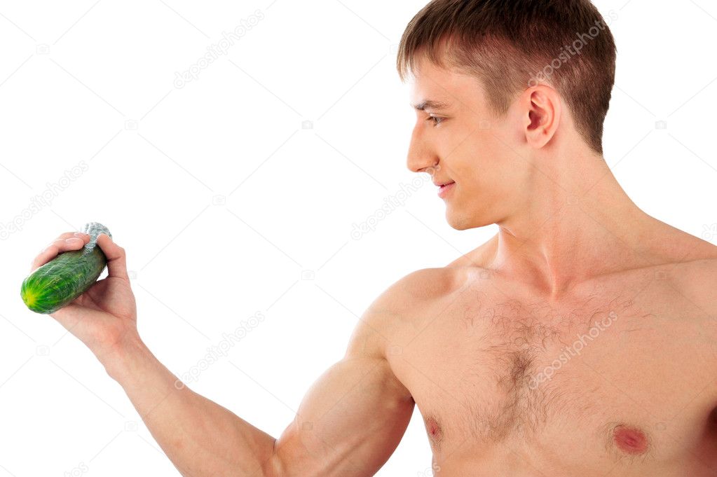 Portrait Of Muscular Young Man holding cucumber and doing exerci