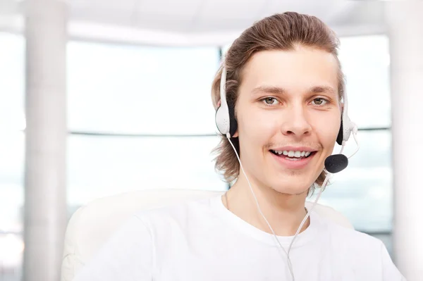 Homem representante de vendas confiante com um fone de ouvido em seu workpl — Fotografia de Stock