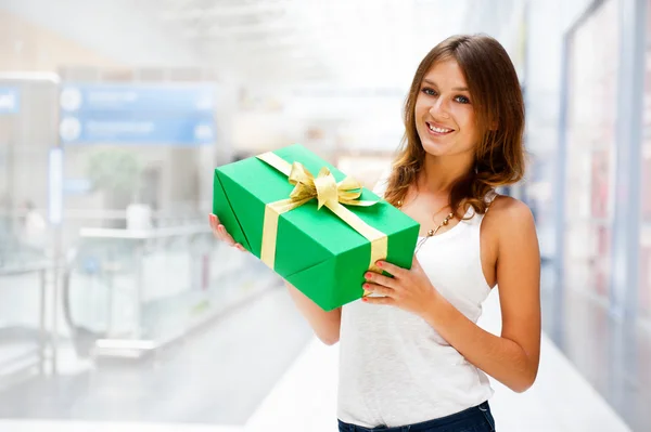 Vacker brunett kvinna med en gåva fält står inne i Shop — Stockfoto