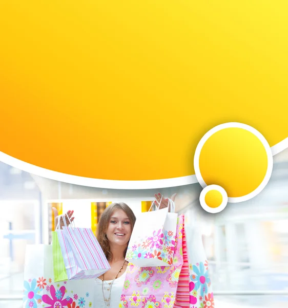Donna della spesa con un sacco di borse sorride all'interno del centro commerciale. Lei è happ — Foto Stock