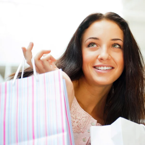 Nahaufnahme Porträt einer jungen glücklichen Frau mit Einkaufstüten im Einkaufszentrum — Stockfoto