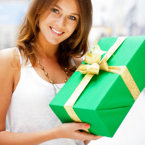 Mulher morena bonita com um boxe presente em pé dentro shoppi — Fotografia de Stock