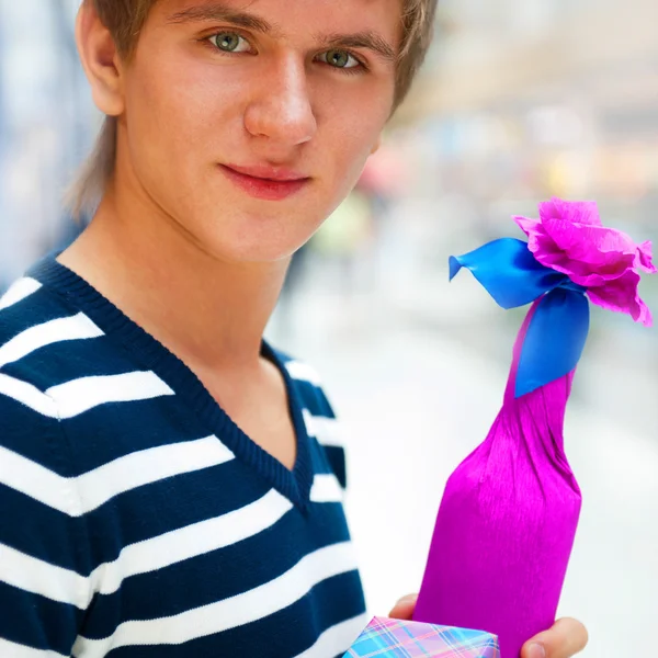 Πορτραίτο ενός άνδρα με μια συσκευασία δώρου και μπουκάλι στο εμπορικό κέντρο ή — Φωτογραφία Αρχείου