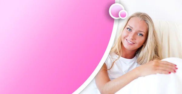 Ung blond kvinna njuter en solig morgon i sängen — Stockfoto