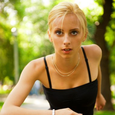 Portrait of young beautiful woman in sportswear running in park. clipart