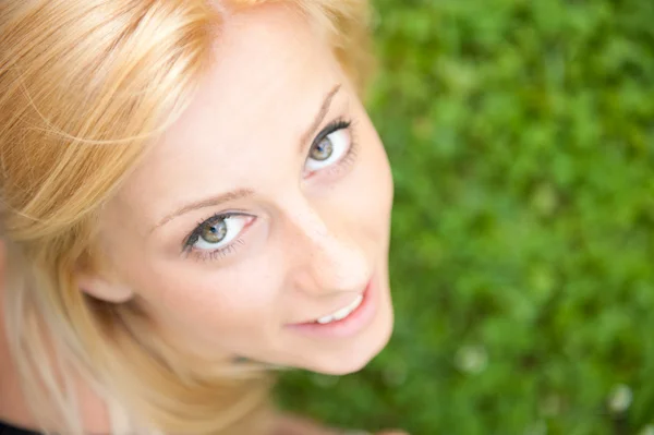Sonriente hermosa mujer tendida en la hierba. Sonriendo. Foto de abo — Foto de Stock