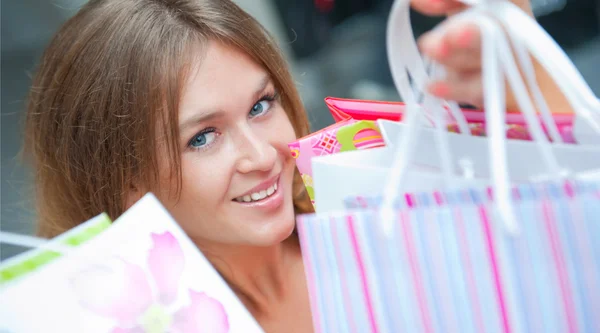 Щаслива жінка в торговому центрі тримає сумки з відкритими руками. Сюди — стокове фото