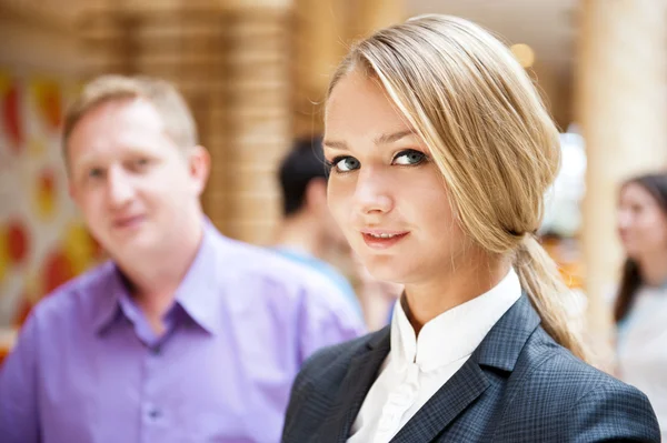 Porträt einer netten Geschäftsfrau mit Kollegen im Hintergrund — Stockfoto
