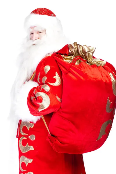 Санта Клаус стоит на белом фоне со своей сумкой, полной — стоковое фото
