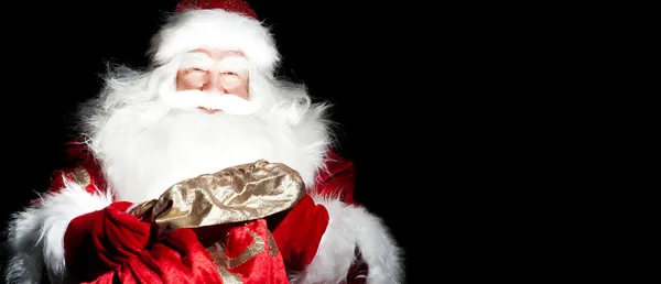 Санта сидит в рождественской комнате и смотрит в мешок — стоковое фото