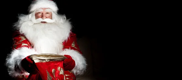 Santa sentado en la habitación de Navidad y mirando en el saco —  Fotos de Stock
