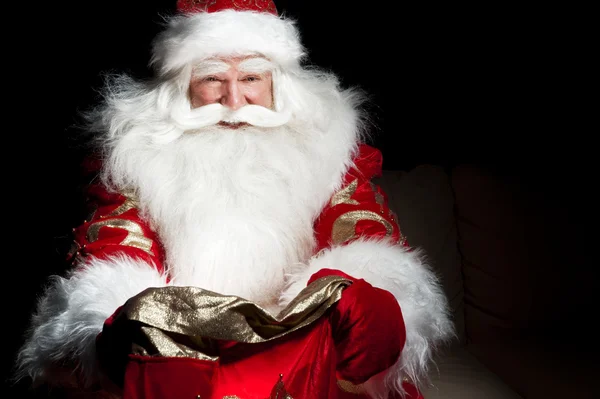 Santa sentado en la habitación de Navidad y mirando en el saco — Foto de Stock