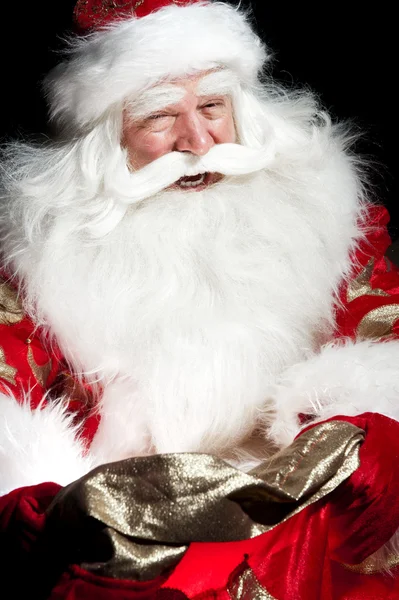 Santa sitter vid jul rum och tittar in i säcken — Stockfoto