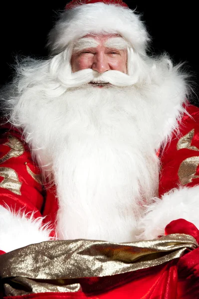 Weihnachtsmann sitzt im Weihnachtszimmer und schaut in den Sack — Stockfoto