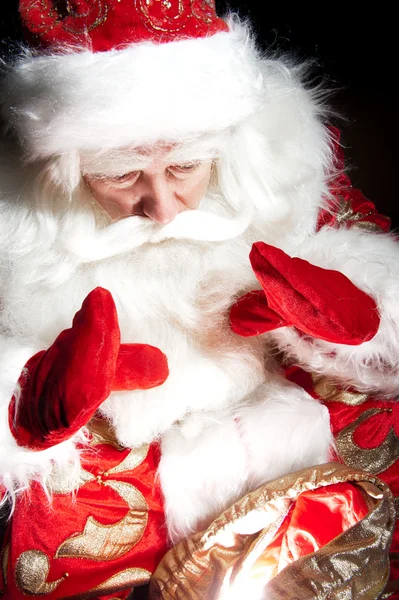 Santa sitting at the Christmas room and looking into the sack — Stock Photo, Image