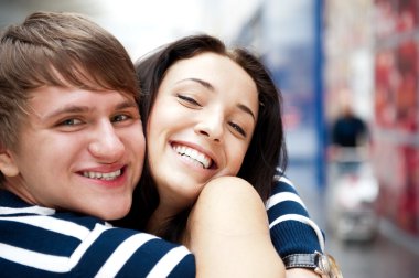 Young man meeting his girlfriend with opened arms at airport arr clipart