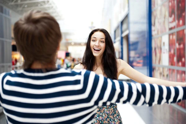 Молодий чоловік зустрічається зі своєю дівчиною з відкритими обіймами в аеропорту — стокове фото