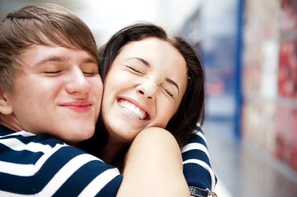 Junger Mann trifft seine Freundin mit offenen Armen am Flughafen — Stockfoto