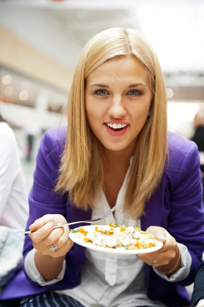 フルーツ サラダを食べて魅力的な若い女性のクローズ アップの肖像画 — ストック写真