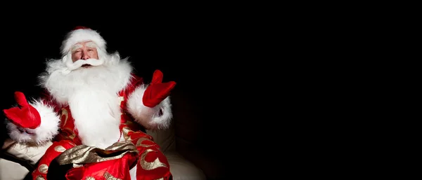 Babbo Natale seduto con un sacco al coperto nella stanza buia notte — Foto Stock