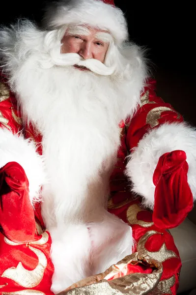 Santa sedí s vnitřní pytel v temné noci pokoj — Stock fotografie