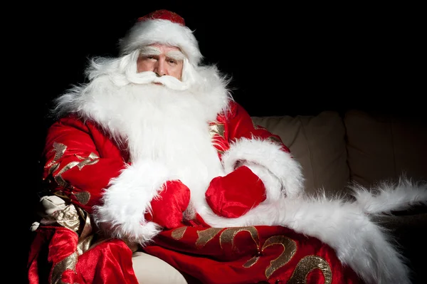 Santa κάθεται με ένα τσουβάλι εσωτερική αίθουσα σκοτεινή νύχτα — Φωτογραφία Αρχείου
