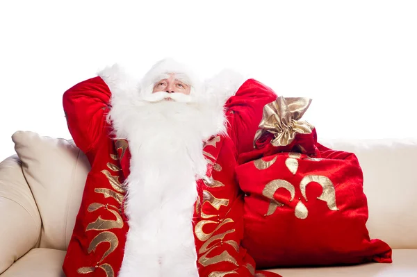 Tradicional Santa Claus descansando en el sofá en el interior y soñando despierto . — Foto de Stock