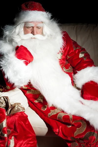 Santa sentado com um saco interior na noite escura quarto — Fotografia de Stock
