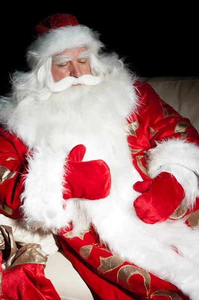 Santa sitter med en säck inomhus på mörka natt rum — Stockfoto