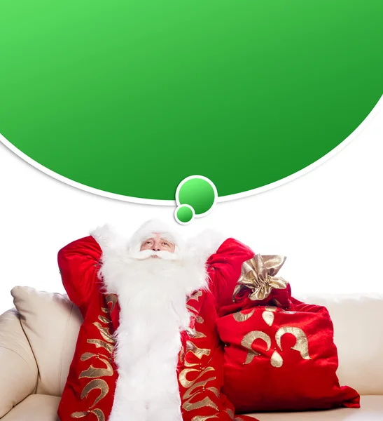 Traditional Santa Claus resting on sofa indoors and daydreaming. — Stock Photo, Image