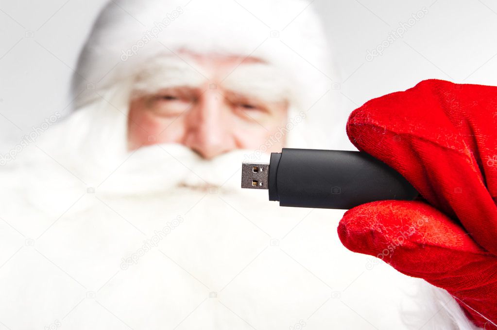 Traditional Santa Claus holding 3g usb modem in his arm on foreg