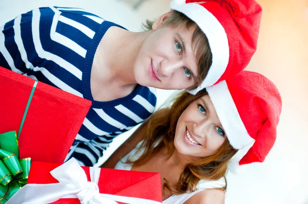 クリスマスの幸せなカップル一緒に立っていると holdi を帽子します。 — ストック写真