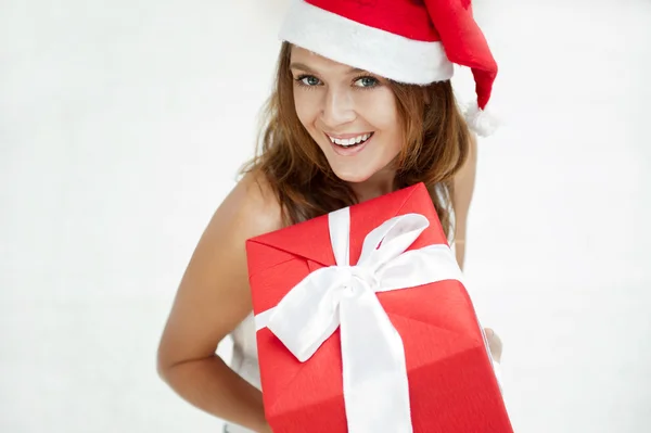 Szczęśliwa dziewczyna w Boże Narodzenie kapelusz. Stojący w pomieszczeniu i gospodarstwa — Zdjęcie stockowe