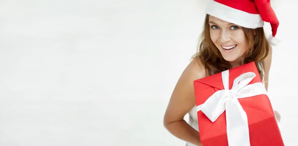 Glad flicka i jul hatt. stående inomhus och hålla — Stockfoto