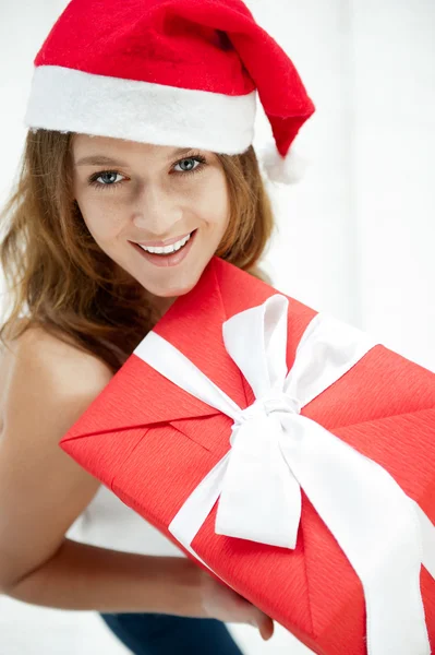 Šťastná dívka v klobouku vánoční. uvnitř stojí a drží — Stock fotografie