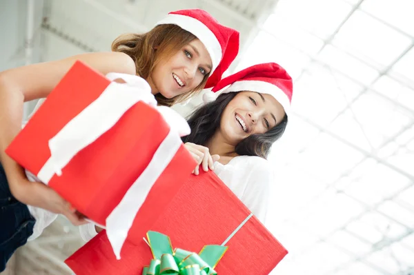 Νεαρά κορίτσια ευτυχισμένη σε hats.standing Χριστούγεννα μαζί στο εσωτερικό μια — Φωτογραφία Αρχείου