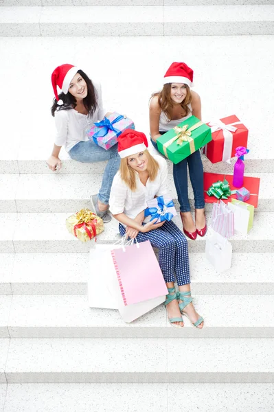 Group of three beautiful girls sitting on stairs at shopping mal — Stock Photo, Image