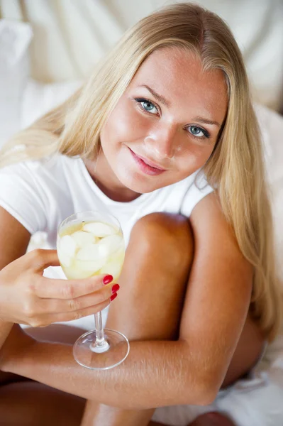 Woman drinking fresh ice tea beverage and looking at camera whil — Stock Photo, Image