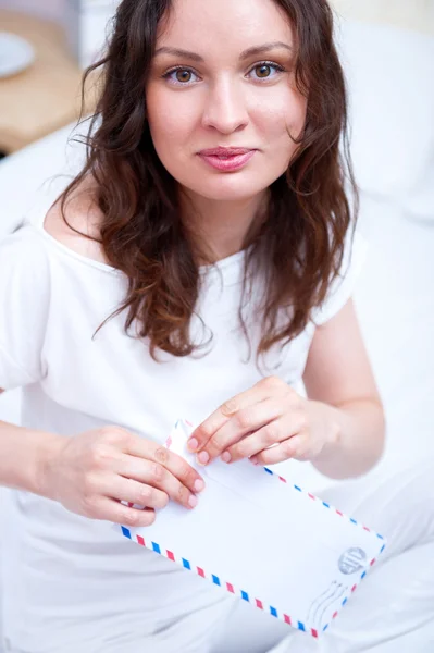 Mutlu bir kadın yatak odasında bir mektup okuma. o bir Letonyalı alınan — Stok fotoğraf
