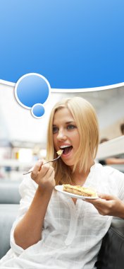 Portrait of young pretty smiling woman eating cake at shopping m clipart