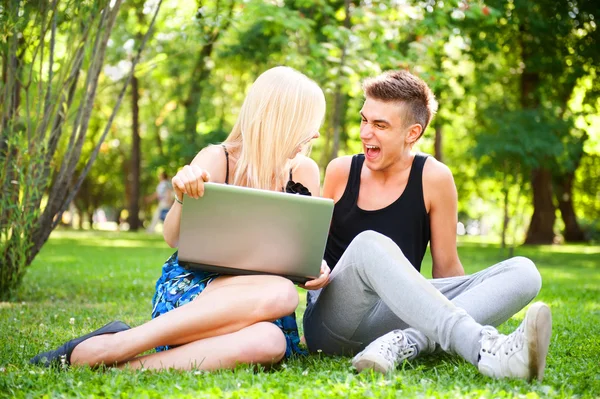Jeune couple souriant heureux avec ordinateur portable au pique-nique — Photo