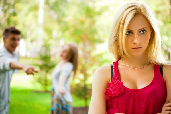 Upset teenage girl being jeered by group of the other young peop — Stock Photo, Image