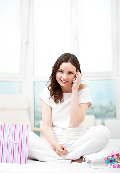 Portrait of young beautiful awake woman with gifts on bed at bed — Stock Photo, Image