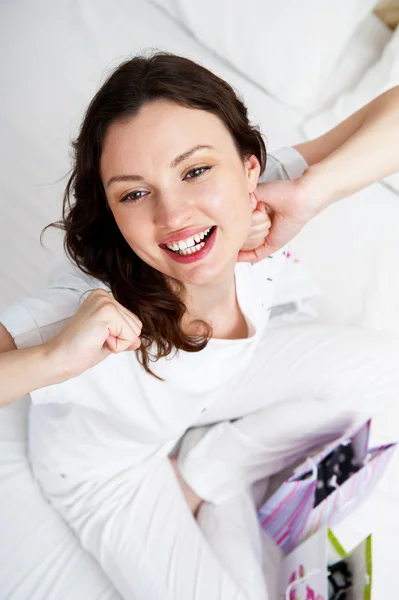 Портрет молодой красивой проснувшейся женщины с подарками на кровати у постели — стоковое фото