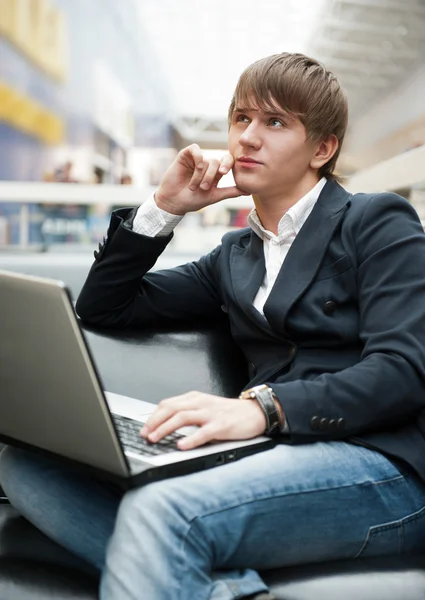 Retrato del joven guapo que trabaja con el ordenador portátil en la cafetería en bu —  Fotos de Stock