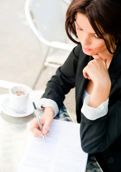 Portret zbliżenie ładny kobieta siedząc w kawiarni i podpisanie dokumentu — Zdjęcie stockowe